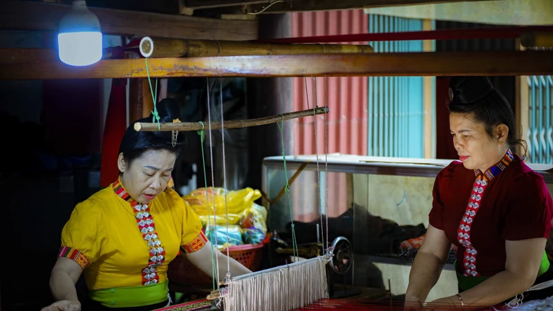 傣族妇女每日在织布机旁专注编织色彩斑斓的土锦布。图自越通社