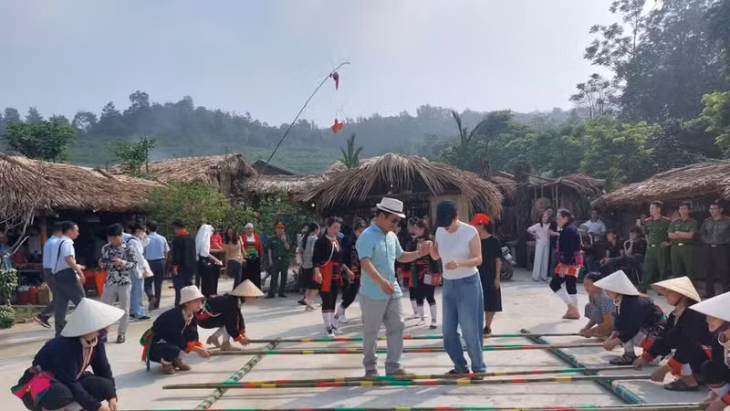 游客在巴维板绵村社区旅游点跳竹竿舞。图自越通社