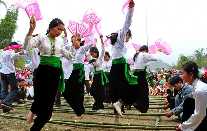 老街省傣族妇女身着传统服饰参加跳竹竿舞。
