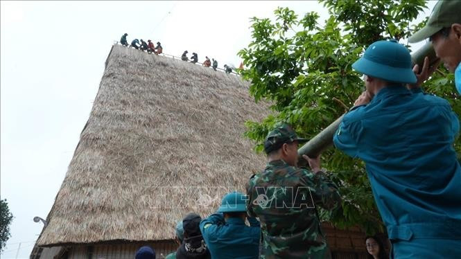 边防部队帮助村民共同修缮坤索拉龙屋屋顶。 nha-rong3-140425.jpg
