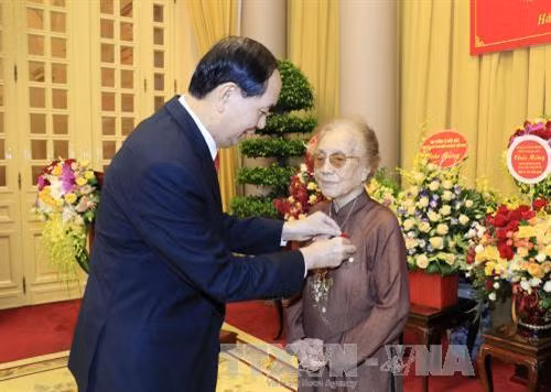 陈大光向前国家副主席阮氏萍颁发70年党龄纪念章。（图片来源：越通社）