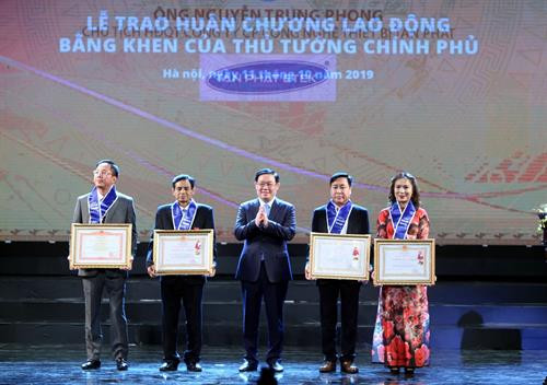 王廷惠在活动中向部分企业授予劳动勋章。图自越通社