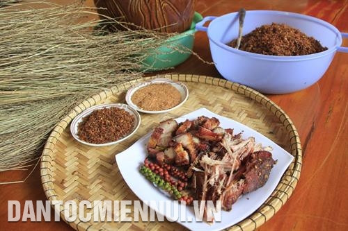 把肉片用竹签串好并搁在灶膛上面烘干。记者 红叠 摄 烟熏猪肉、黄蚂蚁盐、陶罐竹管酒是嘉莱族春节餐桌上必不可少的美食文化。记者 红叠 摄