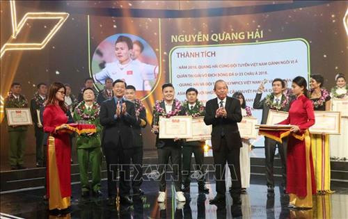 越共中央政治局委员、政府常务副总理张和平向越南足球运动员阮光海授予奖状 图自越通社