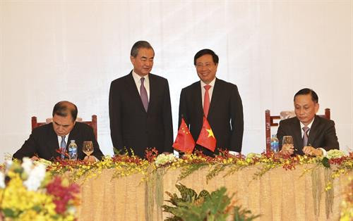 越南政府副总理兼外长范平明和中国外长王毅出席签署仪式。（图片来源：越通社）