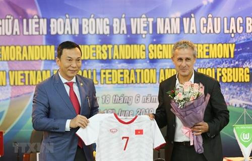 越南足球协会常务副主席陈国俊向德国Wolfsburg队大使赠送越南足球队的衣服。图自越通社