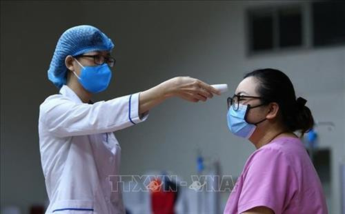 医务人员进行体温测量。图自越通社 医务人员进行体温测量。图自越通社