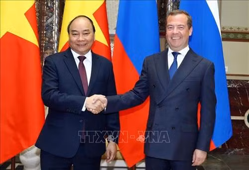 越俄两国总理亲切握手。图自越通社