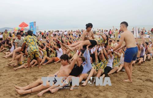 旅外越侨青年代表团在美丽的炉门海滩上举行的各项活动。(图片来源:越通社) 旅外越侨青年代表团在美丽的炉门海滩上举行的各项活动。(图片来源:越通社)