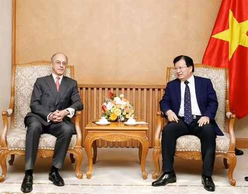 越南政府副总理郑廷勇与英国怡和集团执行董事詹姆士•沙逊勋爵亲切握手。（图片来源：越通社）