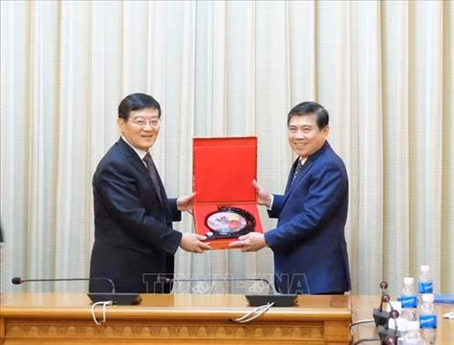 胡志明市人民委员会副主席阮成峰向中华全国工商业联合会党组书记、常务副主席徐乐江赠送礼物。图自越通社