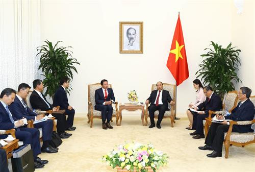 政府总理阮春福(右)会见韩国SK集团董事长崔泰源。 图自越通社
