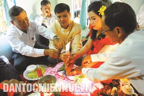 新娘家和新郎家把细线系在新娘和新郎的手腕上。