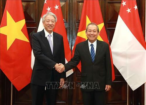 政府副总理张和平（右）与新加坡副总理张志贤握手。图自越通社