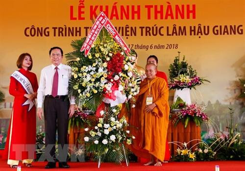 越南祖国阵线中央委员会主席陈青敏向后江竹林禅院赠送鲜花。（图片来源：越通社）