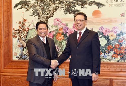 范明正同志（左）与中共中央政治局委员、中央书记处书记、组织部部长陈希亲切握手。越通社记者 永河 摄