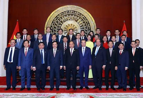 越南政府总理阮春福与越南驻中国大使馆工作人员和旅华越南人代表合影。图自越通社