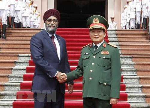 越南国防部部长吴春历和加拿大国防部长哈吉特·辛格萨吉。(图片来源：越通社）