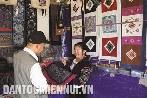 操氏冲女士向外国游客推介1号土锦俱乐部编织的土锦产品。