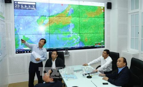 阮春福观察第12号台风的路径。（图片来源：越通社）