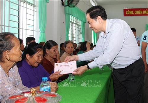越南祖国阵线中央委员会主席陈青敏向石春乡优抚家庭赠送慰问品。图自越通社