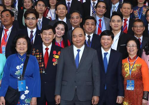 政府总理阮春福与归国出席“2019年家乡之春”活动的越侨代表合影。（图片来源：越通社）