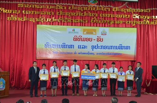 在老越南企业向贫困优秀学生颁发助学金。图自越通社 在老越南企业向贫困优秀学生颁发助学金。图自越通社