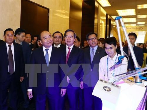 越南政府总理阮春福参观第四次工业革命技术展览会的展位。（图片来源：越通社）