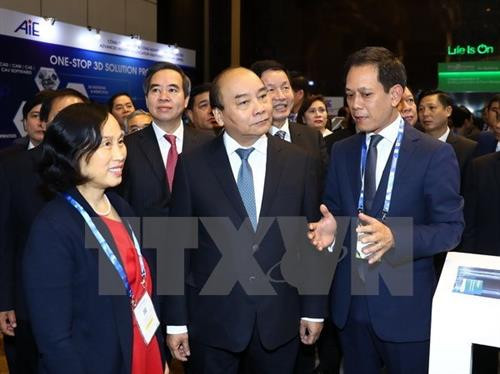 越南政府总理阮春福参观第四次工业革命技术展览会的展位。（图片来源：越通社）