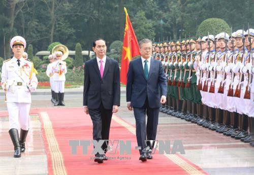 越南国家主席陈大光和韩国总统文在寅检阅仪仗队。（图片来源：越通社）