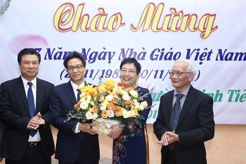 政府副总理武德儋向丁先皇高中学校教师送花表示祝贺。图自越通社 政府副总理武德儋向丁先皇高中学校教师送花表示祝贺。图自越通社