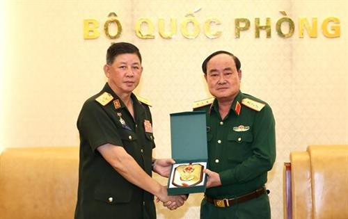 越南国防部副部长陈丹上将向老挝人民军总后勤局主任翁坎·风马坤赠送纪念品。图自越通社