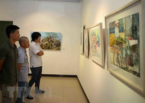 参观摄影展上展示的作品 图自越通社