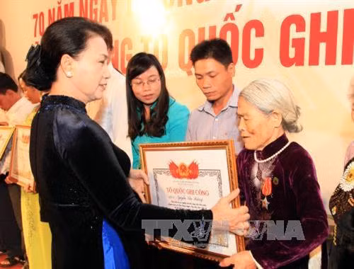 国会主席阮氏金银向烈士家属颁发“祖国记功”证书。（图片来源：越通社）