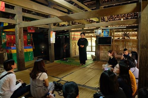 岱依族人阮氏川正在向游客们介绍岱依族文化。图自越通社 岱依族人阮氏川正在向游客们介绍岱依族文化。图自越通社