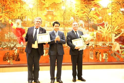 河内市人民委员会主席阮德钟（左二）向两名法国公民授予“致力于首都建设事业”称号。（图片来源：因特网）