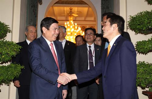 胡志明市人民委员会主席阮成峰（左）和日本爱媛县知事中村時広握手。（图片来源：越通社）