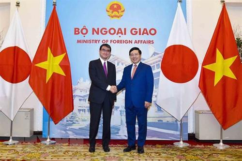 越南政府副总理兼外交部长范平明(右)与日本外务大臣河野太郎握手 图自越通社