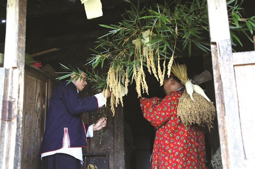 巫师将一束稻穗交给一家之主，并对他们说一年丰收，稻谷满仓的祝词。