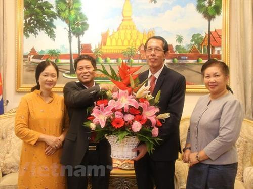 黎贵琼（左）向老挝驻马来西亚大使Houmdaophone Soukhaseum赠送鲜花，祝贺老挝国庆43周年。图自越通社