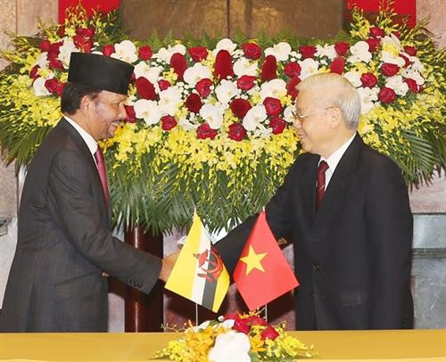 越共中央总书记、国家主席阮富仲（右）与莱达鲁萨兰国苏丹哈吉·哈桑纳尔·博尔基亚（左）亲切握手。图自越通社