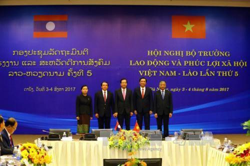 两国劳动部长同与会代表合影留念。（图片来源：越通社）