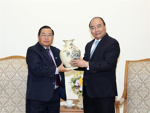 越南政府总理阮春福（右）向老挝国会副主席森暖赠送纪念品。（图片来源：越通社）