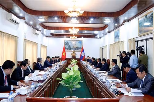 明慨率团同由老挝国家监察署长本通·吉马尼举行工作会谈。（图片来源：越通社）