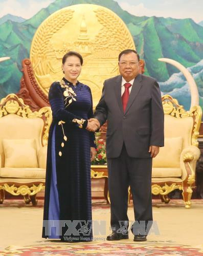 越南国会主席阮氏金银与老挝人民革命党中央总书记、国家主席本扬•沃拉吉握手。（图片来源：越通社）