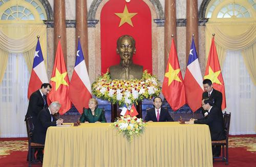 越南国家主席陈大光和智利共和国总统米歇尔·巴切莱特·赫里亚出席双方合作文件签字仪式。（图片来源：越通社）