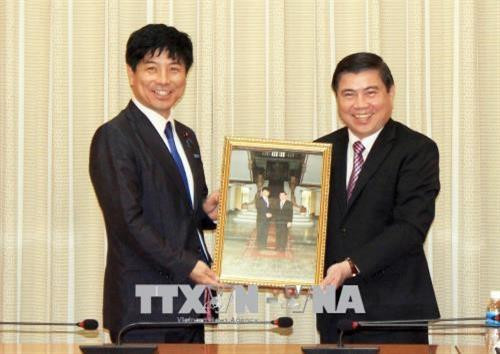 胡志明市人民委员会主席阮成峰向日本外务省副大臣中根一幸赠送礼物。（图片来源：越通社）