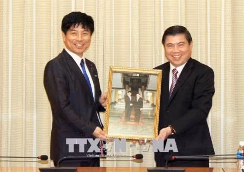 胡志明市人民委员会主席阮成峰向日本外务省副大臣中根一幸赠送礼物。（图片来源：越通社）