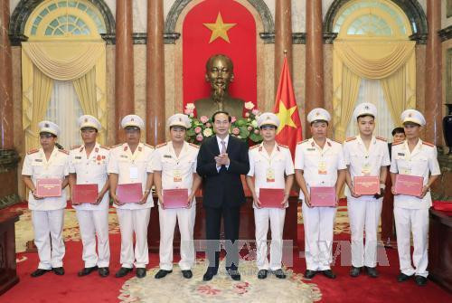 越南国家主席陈大光与人民警察力量的伤残军人、烈士家属及先进模范代表团举行会面。（图片来源：越通社）