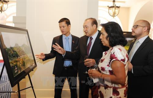 与会代表参观图片展。（图片来源：越通社）